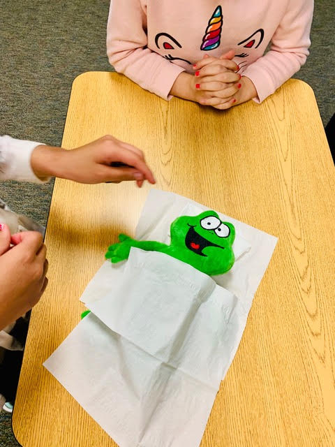 Two students have tucked a Zac stuffed animal in between to tissues for a nap at school.
